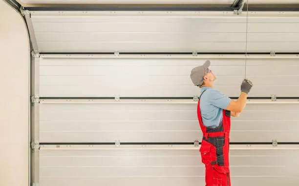 person pulling garage door with red suit -garage door installer